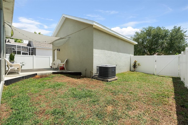 back of property with a lawn and central AC