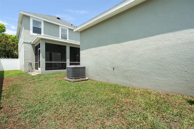 back of house with a yard, central AC unit, and a sunroom