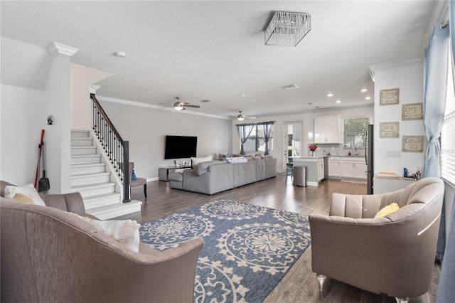 living room with ceiling fan, ornamental molding, and dark hardwood / wood-style flooring