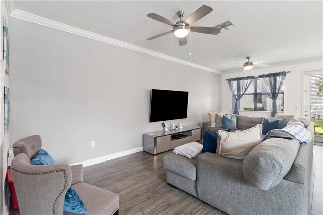 living room with ornamental molding, dark wood-type flooring, and a textured ceiling