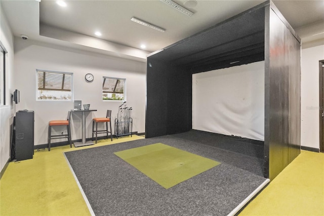 game room with golf simulator and light colored carpet