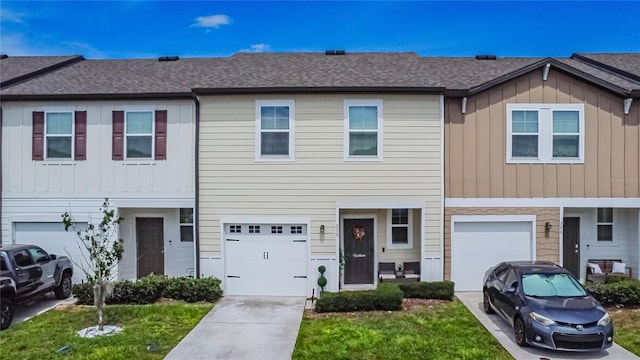 multi unit property featuring a garage and a front lawn