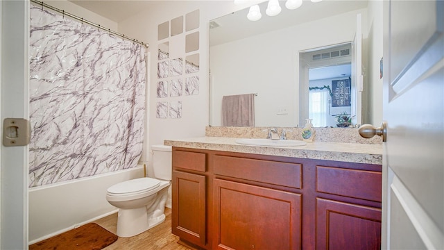 full bathroom with hardwood / wood-style floors, vanity, toilet, and shower / tub combo with curtain