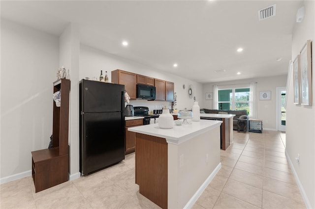 kitchen featuring light tile patterned flooring, a kitchen island, and black appliances