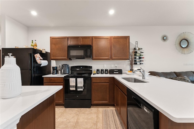 kitchen with kitchen peninsula, light tile patterned floors, sink, and black appliances