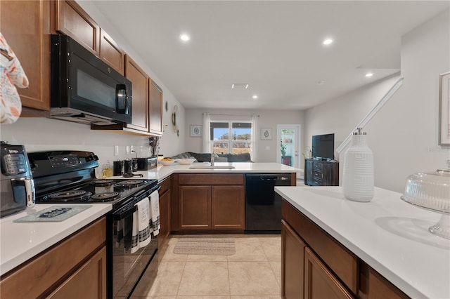 kitchen featuring black appliances, light tile patterned flooring, kitchen peninsula, and sink