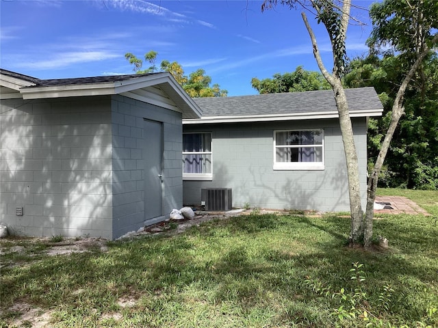 101 Albert St, Winter Springs, FL 32708 - view of home's exterior with a yard, central AC unit, roof with shingles, and concrete block siding