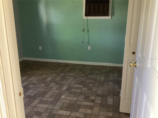 spare room featuring dark tile floors