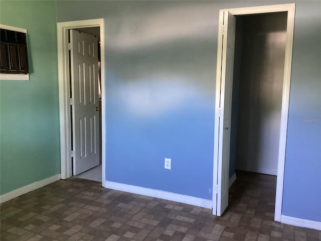 unfurnished bedroom featuring dark tile floors