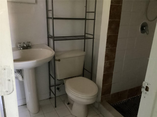 bathroom featuring a tile shower, tile flooring, and toilet