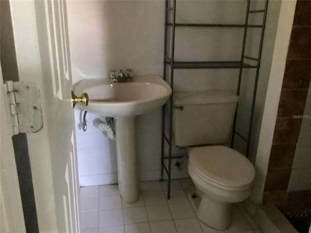 bathroom featuring a shower, tile flooring, and toilet