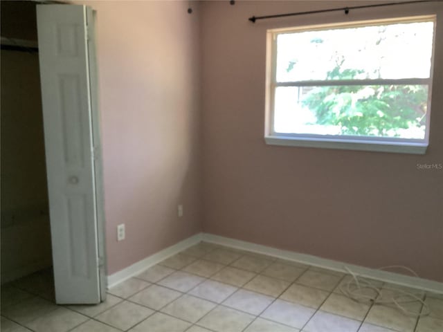 unfurnished bedroom featuring multiple windows and light tile floors