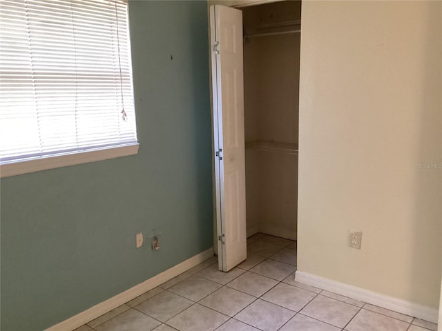 unfurnished bedroom with a closet and light tile flooring