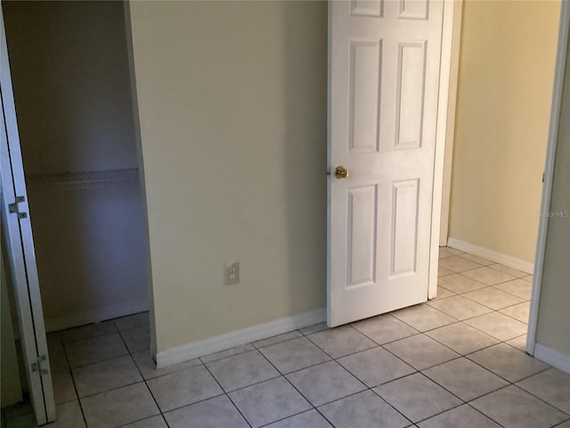 unfurnished bedroom featuring a closet and light tile flooring