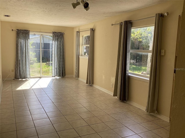 101 Albert St, Winter Springs, FL 32708 - empty room with a textured ceiling, baseboards, light tile patterned floors, and visible vents