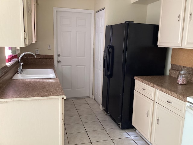 kitchen featuring white cabinetry, sink, black refrigerator with ice dispenser, and light tile floors