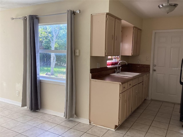 kitchen featuring sink, cream cabinets, and light tile floors