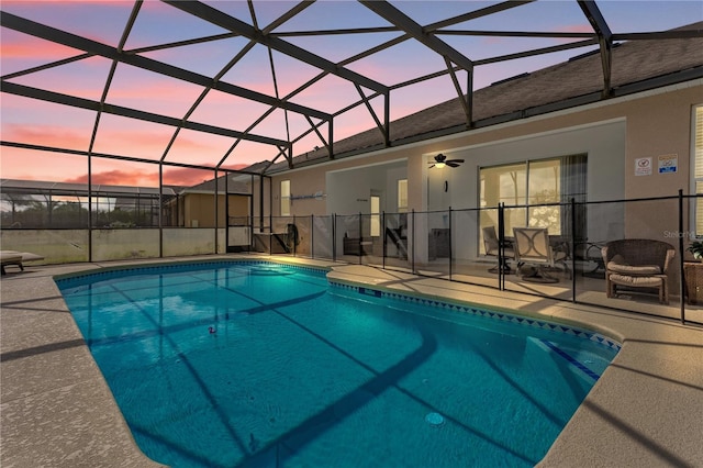 pool at dusk with a patio area, ceiling fan, and a lanai