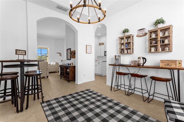 dining space with a chandelier and light tile patterned floors