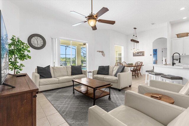 tiled living room with ceiling fan and sink