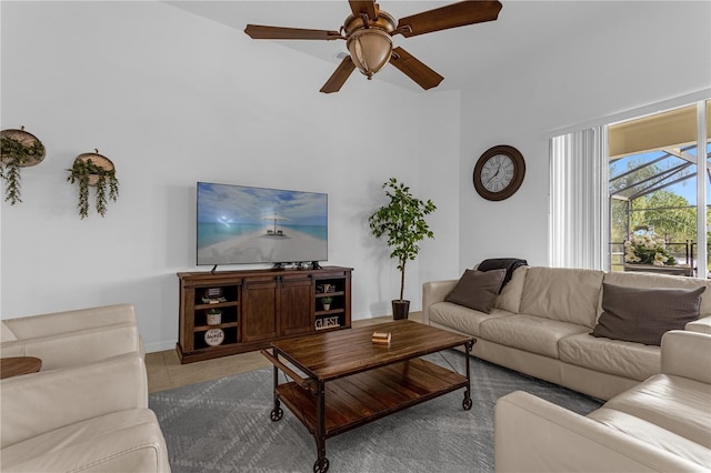 living room with light tile patterned floors, baseboards, and a ceiling fan