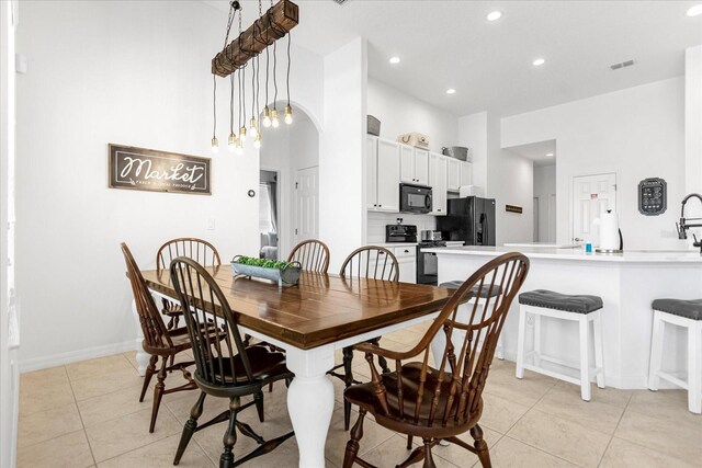 dining room with arched walkways, light tile patterned floors, recessed lighting, visible vents, and baseboards