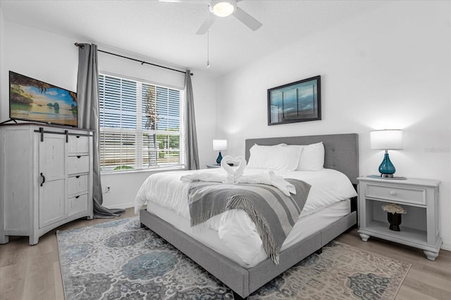 bedroom with ceiling fan and light hardwood / wood-style floors