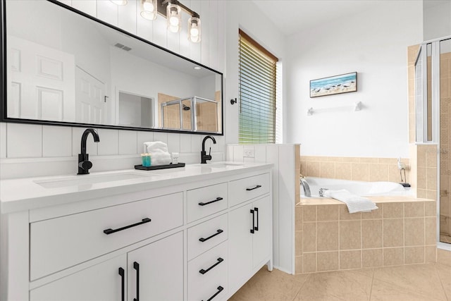 full bathroom with tile patterned flooring, a sink, a shower stall, and double vanity