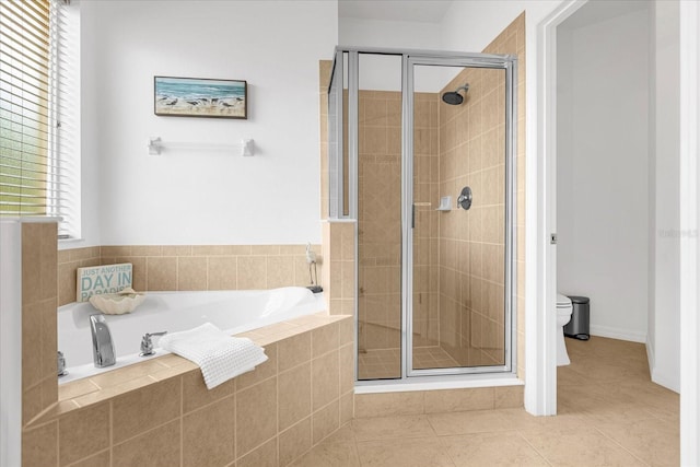 bathroom with a stall shower, a garden tub, toilet, and tile patterned floors