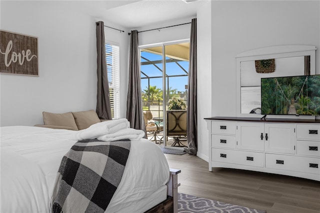 bedroom featuring dark wood-style floors, access to outside, and baseboards