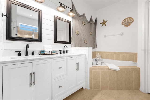 bathroom featuring vanity, tile patterned floors, and tiled tub