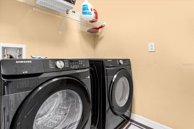 clothes washing area featuring washer and dryer, laundry area, and baseboards