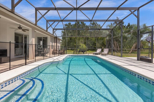 outdoor pool featuring a ceiling fan, a patio area, and glass enclosure