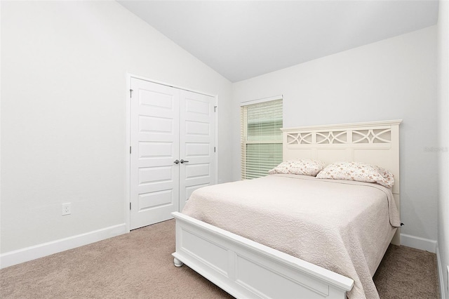 carpeted bedroom featuring a closet and vaulted ceiling