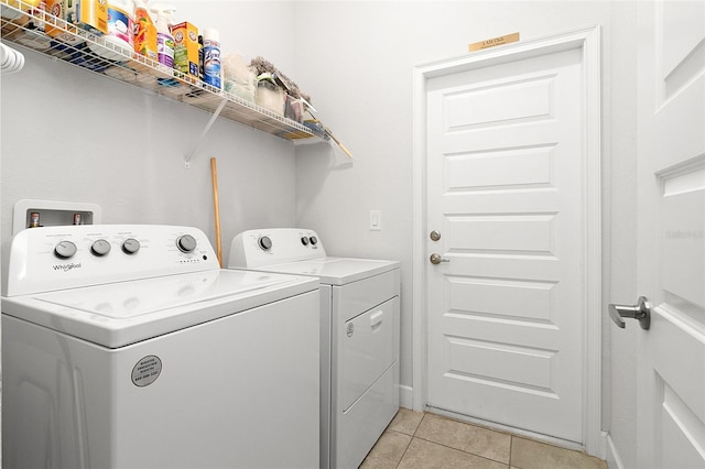 laundry area featuring washing machine and clothes dryer and light tile patterned floors