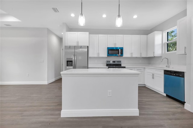 kitchen featuring white cabinetry, pendant lighting, a center island, and stainless steel appliances