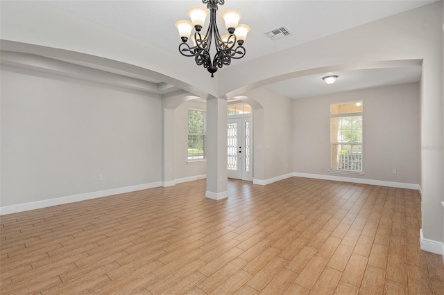 interior space with light hardwood / wood-style floors and a notable chandelier