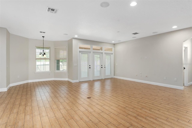 unfurnished living room with light hardwood / wood-style flooring and french doors