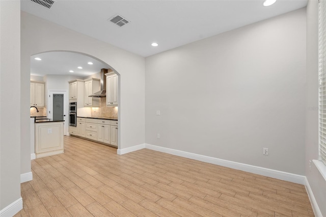 unfurnished living room with sink and light hardwood / wood-style flooring