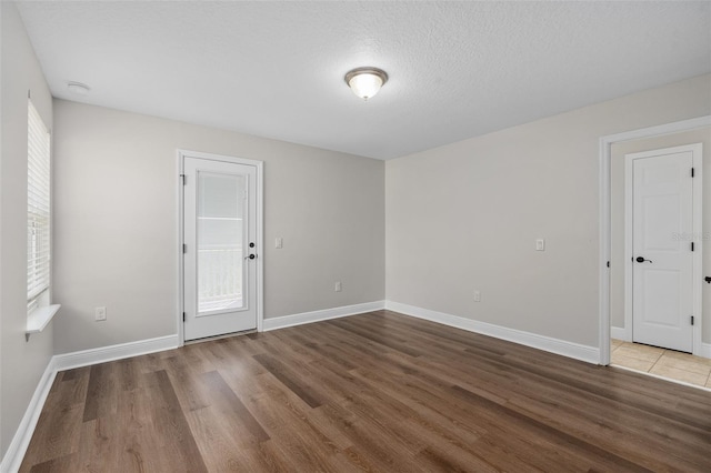 spare room featuring hardwood / wood-style flooring and a textured ceiling