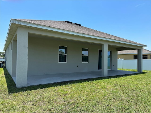 back of property with central AC unit, a yard, and a patio