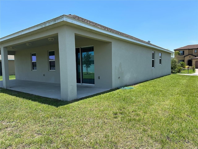 back of property featuring a yard and a patio