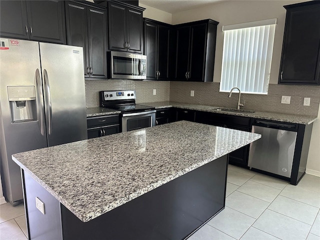 kitchen featuring a center island, light tile patterned floors, sink, and appliances with stainless steel finishes