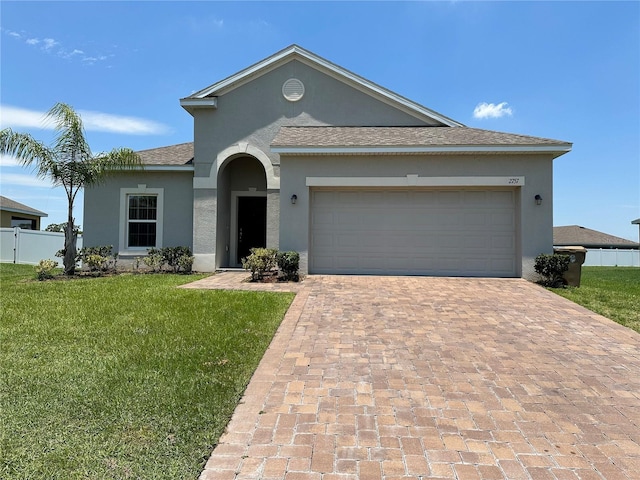 ranch-style home featuring a garage and a front lawn