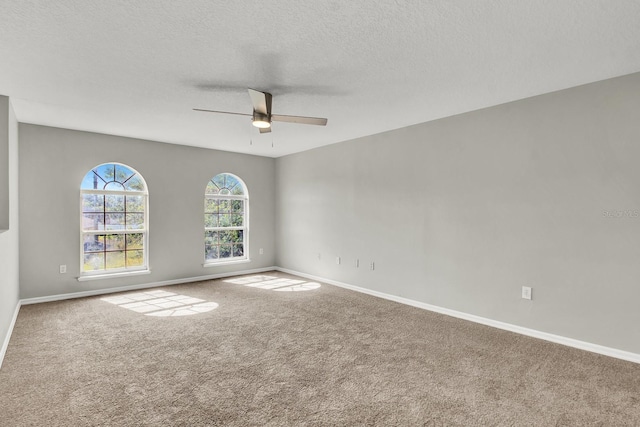 carpeted empty room with ceiling fan and a textured ceiling