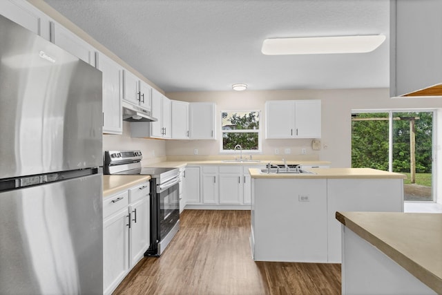 kitchen featuring stainless steel appliances, a kitchen island, sink, light hardwood / wood-style flooring, and white cabinetry