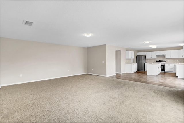 unfurnished living room with dark colored carpet