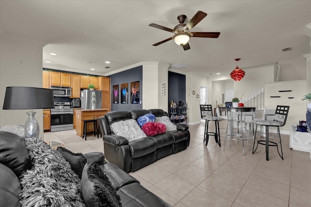 tiled living room featuring crown molding and ceiling fan