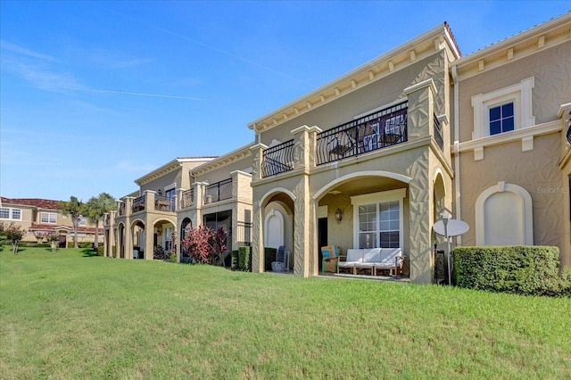 view of front of home featuring a balcony and a front yard