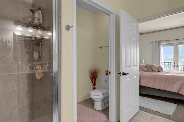 bathroom with tile patterned floors, toilet, and a shower with door